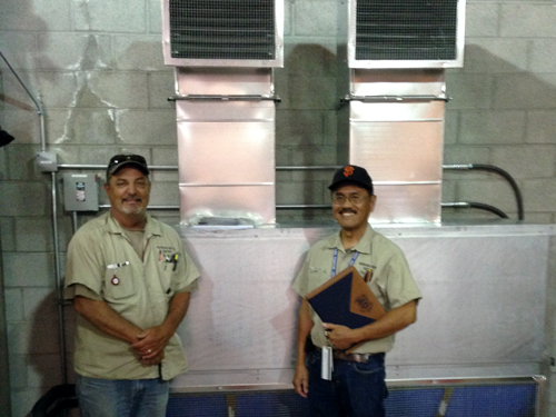 Stewards Anthony Toti and Carl Cagaanan with the new ventilation system at the Meter Repair workshop in San Francisco.
